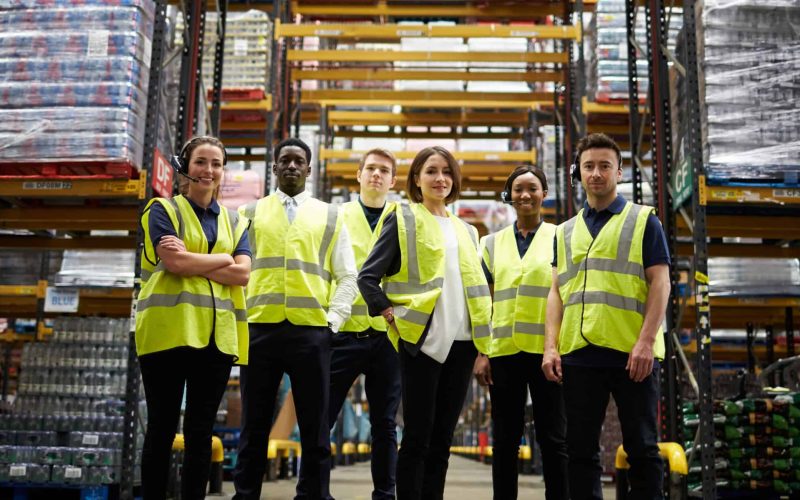 Group portrait of staff at distribution warehouse, low angle